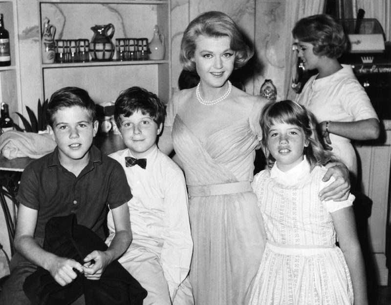  IN DER KÜHLE DES TAGES bekommt Angela Lansbury (zweite von rechts) am Set Besuch von ihren Kindern Anthony Pullen Shaw (Fliege) und Deirdre Angela Shaw (rechts), 1963