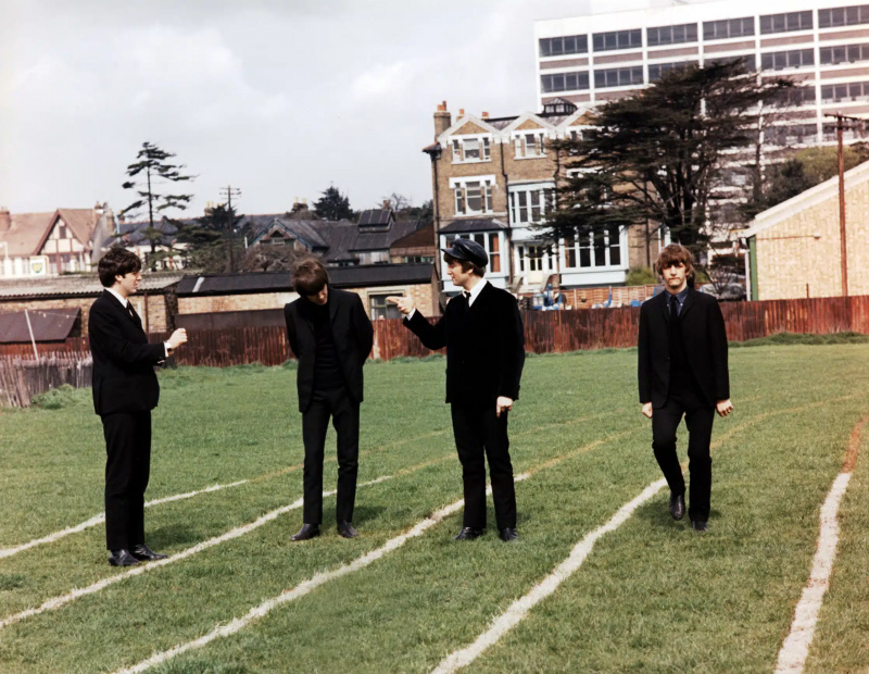  The Beatles : Paul McCartney, George Harrison, John Lennon, Ringo Starr posent sur un terrain de cricket, lors du tournage de A HARD DAY'S NIGHT, 1964