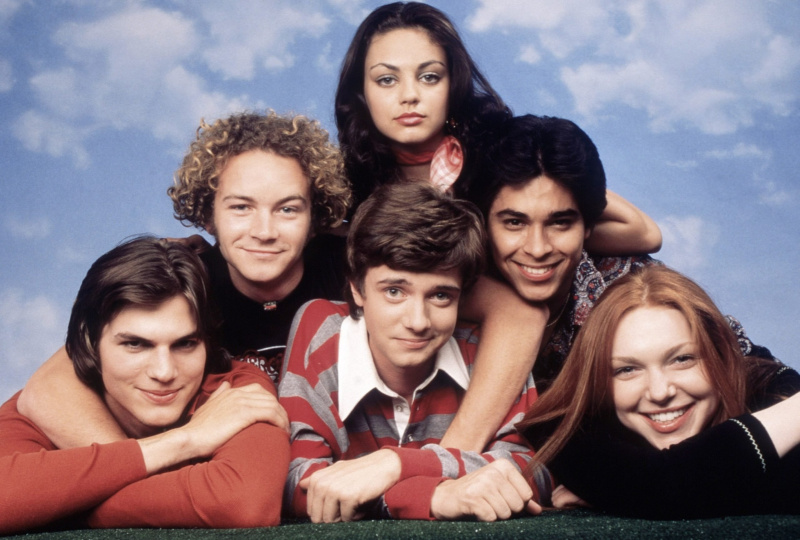 ΟΤΙ'70S SHOW, cast photo. Clockwise from bottom center: Topher Grace, Ashton Kutcher, Danny Masterson, Mila Kunis, Wiler Valderrama, Laura Prepon, (Season 2)